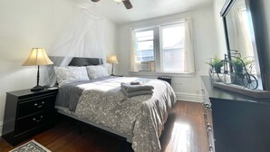 A bedroom with a bed, bedside tables, a ceiling fan, a window, and a mirror. - 6653 2S | Jewel of Central St. Louis (St. Louis)