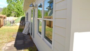 A house with a covered patio, a fenced yard, and a wooden fence.