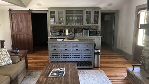 Une cuisine moderne dotée d’appareils électroménagers intégrés, un coin repas avec une table en bois et un salon confortable avec un canapé.