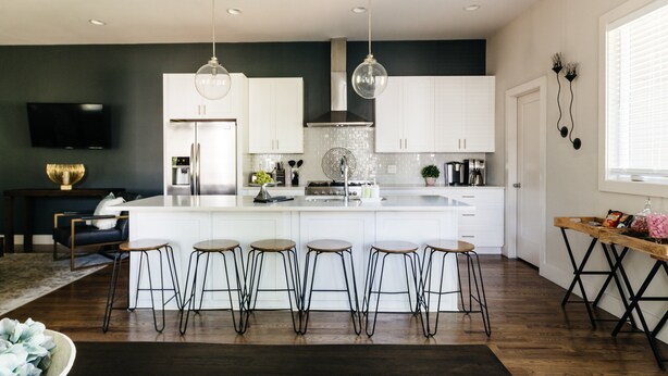 A modern kitchen with white cabinets, a central island with stools, and pendant lighting. - Luxury Home in 12South, Downtown, Gulch, Music Row, Vandy / Roof Tops (Nashville)