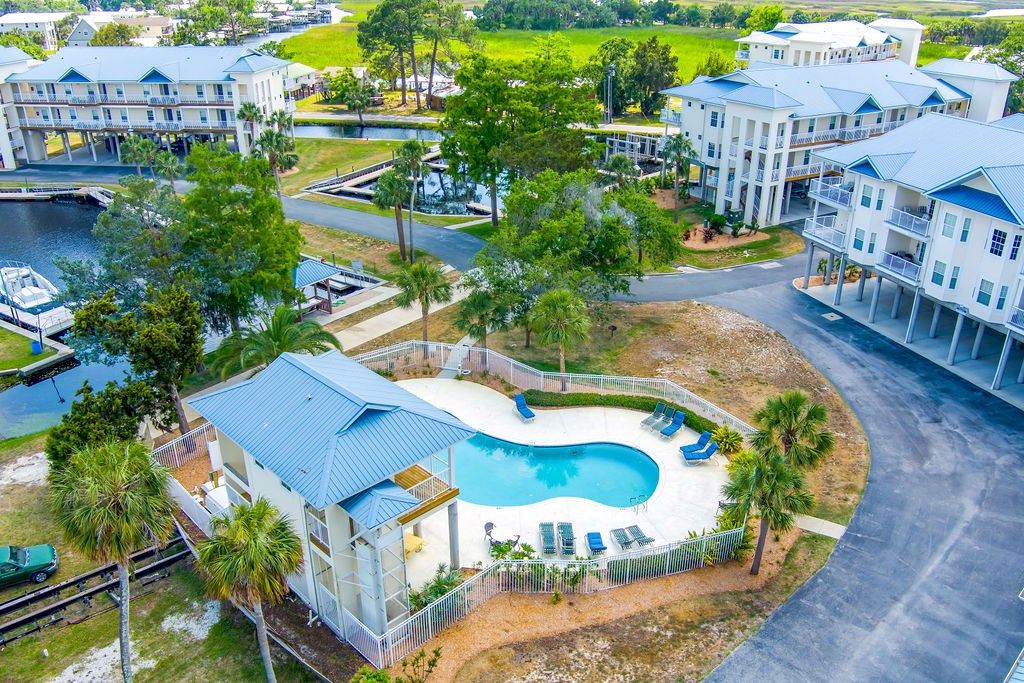 A residential area with a swimming pool, multiple buildings, and a dock.