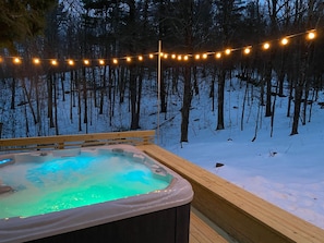 A hot tub surrounded by snow with string lights. - Modern, Minimalist, Light-filled Home with Hot Tub Near Hudson (Craryville)