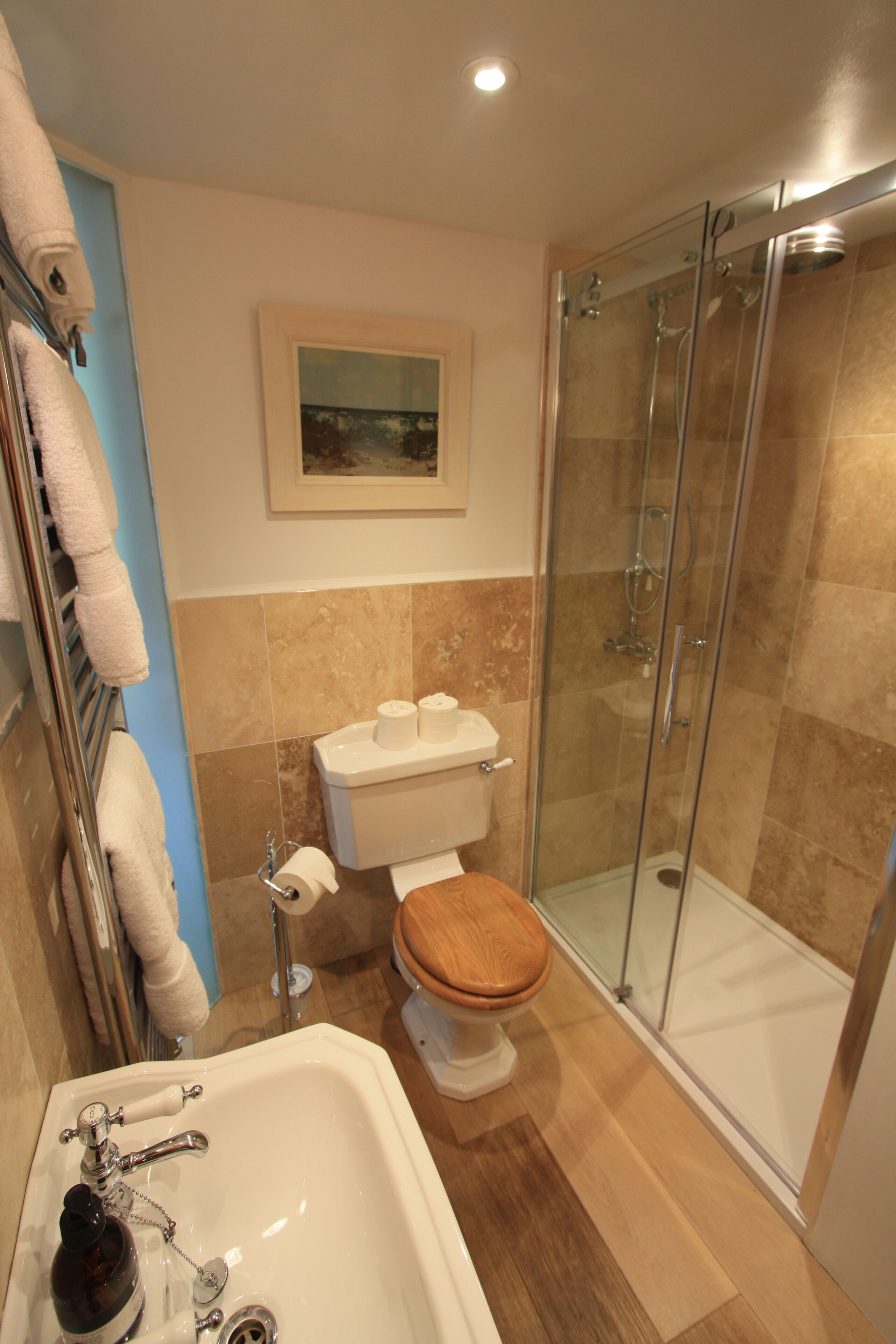 Un baño con bañera, inodoro y ducha de vidrio.