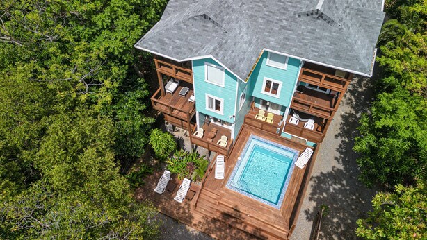 Uma casa de dois andares com um deck espaçoso e uma piscina.
