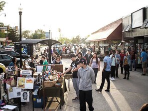 Un marché animé en plein air, avec de nombreux étals et des gens qui flânent.