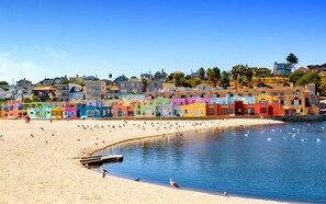 A beach with colorful houses and a calm sea. - Classic Beach House - Walk to Seacliff Beach (Aptos)