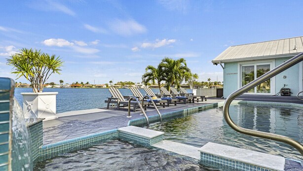 A pool area with lounge chairs and a building labeled "The Beach Club".