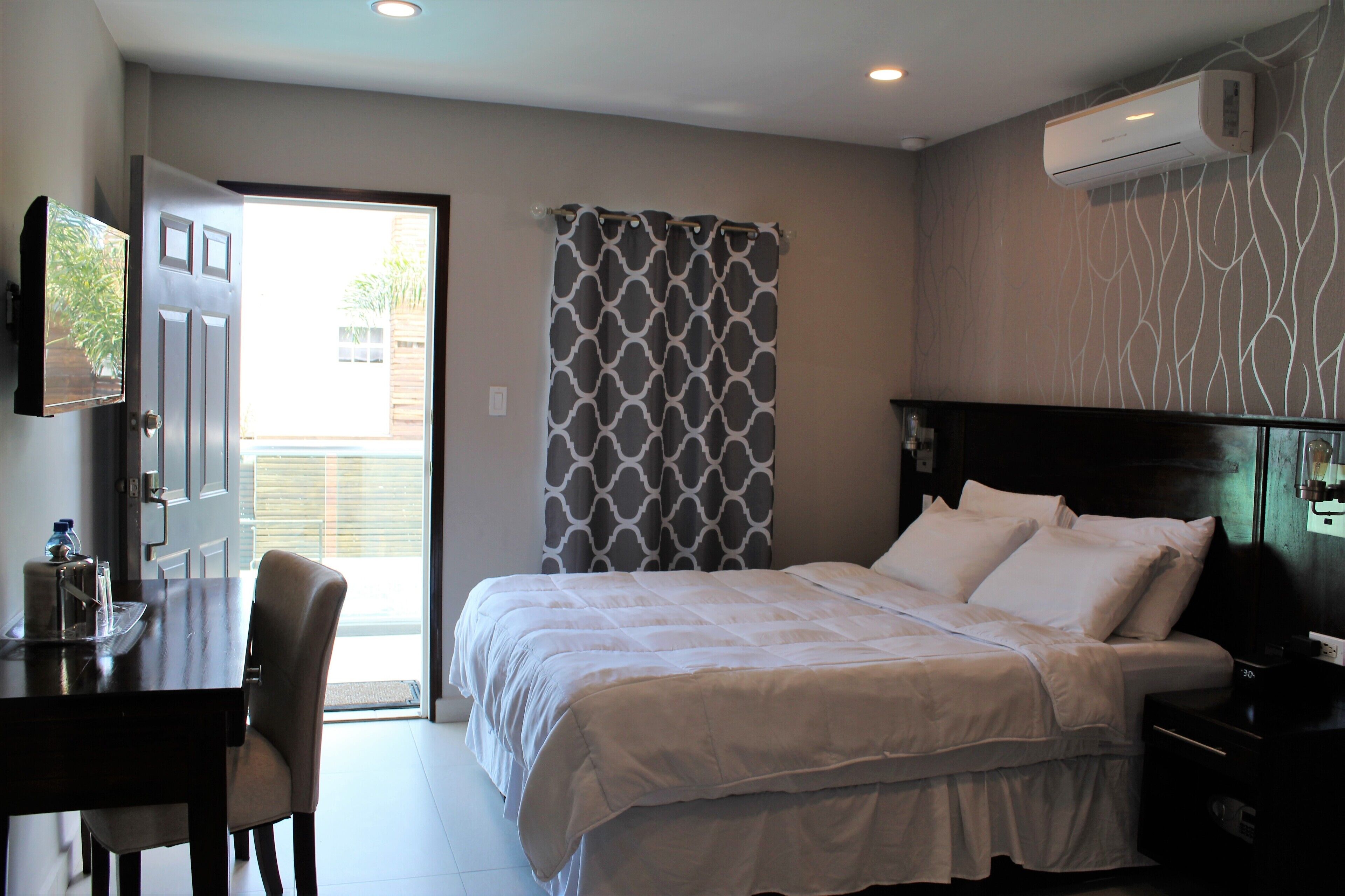 Una habitación de hotel con una cama, un escritorio y una silla.