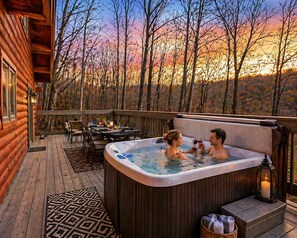 Una cabaña de madera con jacuzzi y terraza, rodeada de árboles.