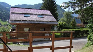 A wooden cabin with a sloped roof, a balcony, and a view of a mountainous landscape. - 2-bedroom apartment near the slopes with terrace and garage in La Clusaz (La Clusaz)