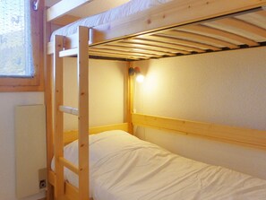 A bunk bed with a ladder, white bedding, and a small window with a curtain. - Family apartment 6 pax, south balcony, near Méribel (Méribel)