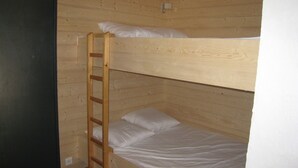 A bunk bed with a wooden ladder, white bedding, and a wooden wall. - 2-Room Apartment, Ski-In/Ski-Out, South Balcony, Comfort for 6 (La Clusaz)