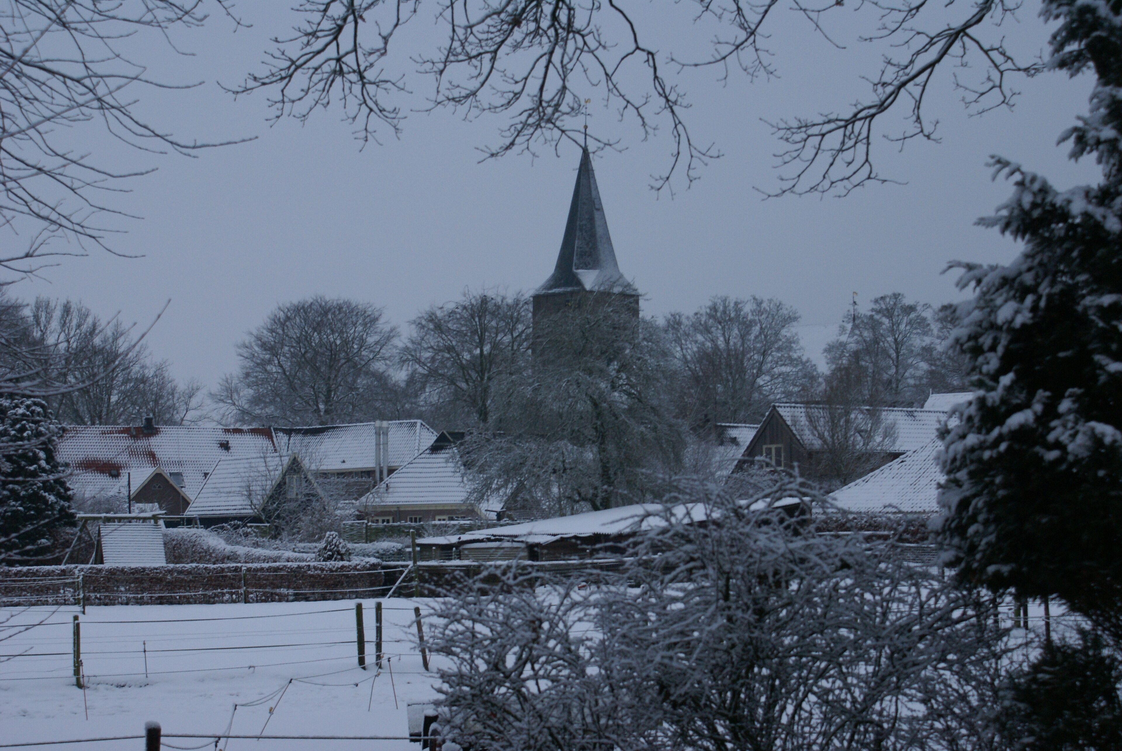 A snow-covered village with a prominent church steeple.