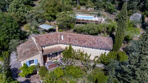 An aerial view of a stone building with a tiled roof, surrounded by dense greenery and trees. - Charming dry-stone house, perfect holidays (Saumane-De-Vaucluse)