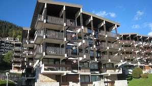 Ein mehrgeschossiges Hotel mit Balkonen, einer Stein-Fassade und einem Parkplatz.
