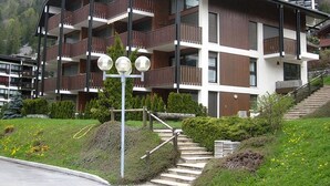 Ein mehrstöckiges Gebäude mit Balkonen, einer Treppe und einer Straßenlaterne.