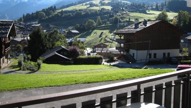 A mountain village with traditional buildings, a barn, and a view of distant mountains. - 1-bedroom near slopes with balcony (La Clusaz)