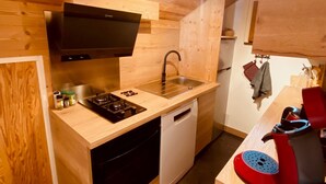 Une cuisine compacte avec des meubles en bois, une cuisinière encastrée, un évier et un lave-vaisselle.