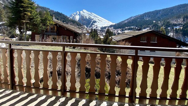 A mountain view from a balcony with a wooden railing. - 3-room apartment with balcony, fireplace, and Wifi in La Clusaz (La Clusaz)