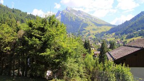 A mountain landscape with a village in the valley, surrounded by greenery and a clear sky. - 3-room apartment with balcony, fireplace, and Wifi in La Clusaz (La Clusaz)