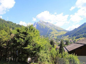 A mountain landscape with a village in the valley, surrounded by greenery and a clear sky. - 3-room apartment with balcony, fireplace, and Wifi in La Clusaz (La Clusaz)