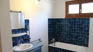A bathroom with a sink, mirror, and bathtub. - 3-room apartment with balcony, fireplace, and Wifi in La Clusaz (La Clusaz)