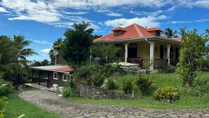 A house with a red roof, a porch, and a stone pathway leading to it.