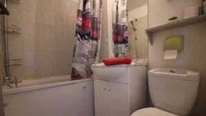 A bathroom with a bathtub, toilet, and sink. - for rent studio gruissan (gruissan)
