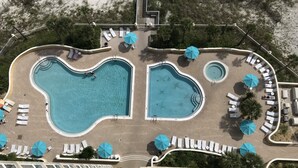An aerial view of a resort with two large swimming pools, sun loungers, and umbrellas. - 𝔾𝕦𝕝𝕗𝔽𝕣𝕠𝕟𝕥 𝑬𝒎𝒆𝒓𝒂𝒍𝒅 𝑰𝒔𝒍𝒆 9th Floor Stocked & Stellar Reviews! (Unknown)