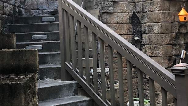 A staircase with stone walls and a wooden railing.