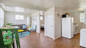 A compact living space with a kitchenette, a dining area with a table and chairs, and a small seating area with a sofa and armchairs. - Affordable for Long Stay, Great for Budget-Friendly Business Travels (Oklahoma City)