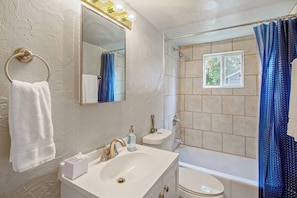Bathtub, hair dryer, towels, shampoo