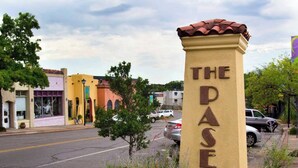 A street sign with "THE DASEO" on a yellow pillar, surrounded by greenery and parked cars. - Affordable for Long Stay, Great for Budget-Friendly Business Travels (Oklahoma City)