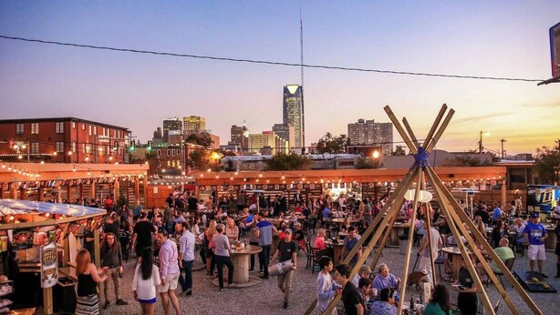 A bustling outdoor market with people and stalls, surrounded by buildings and a clear sky. - Affordable for Long Stay, Great for Budget-Friendly Business Travels (Oklahoma City)