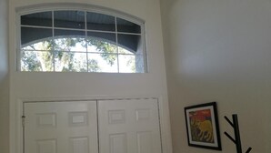 A white door with a window above it, a coat rack, and a framed picture on the wall. - Villa Bonita. Southern Dunes 4 star golf course. Disney and Legoland area. (Haines City)