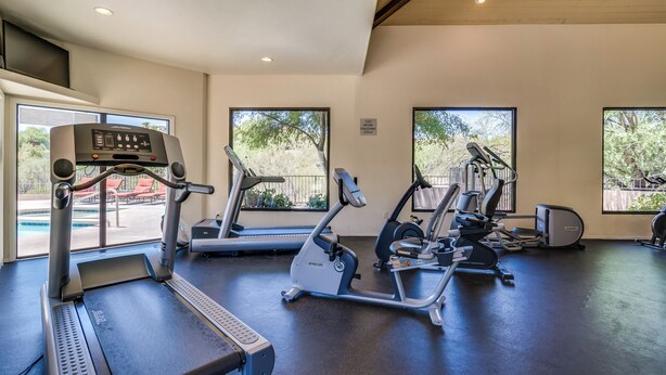 A gym with treadmills, elliptical machines, and weight equipment.