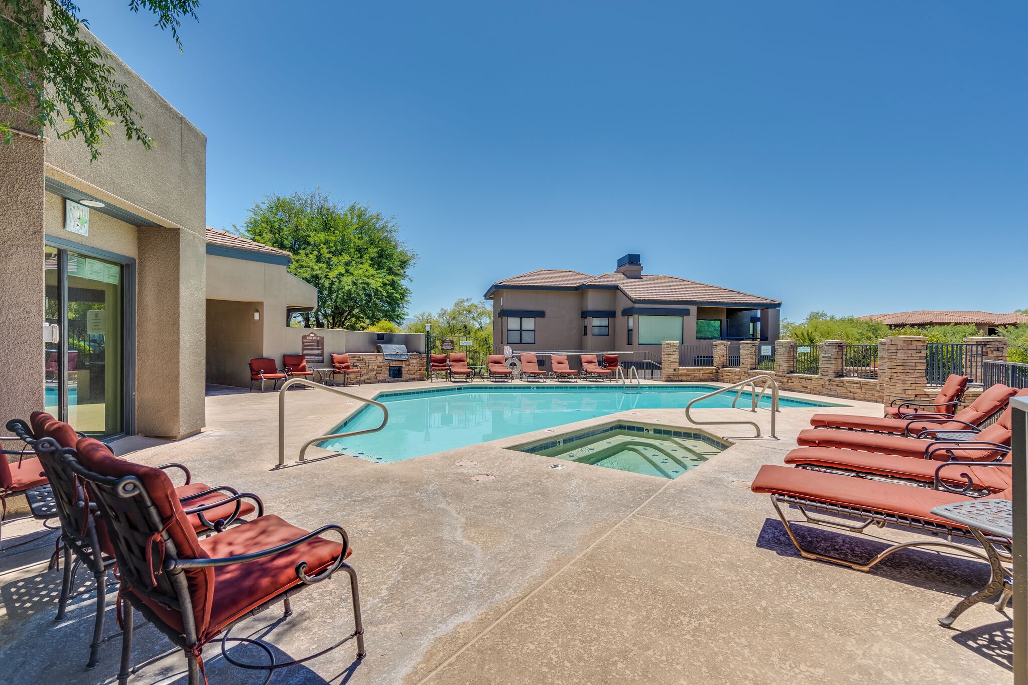 A pool area with lounge chairs and a building in the background.