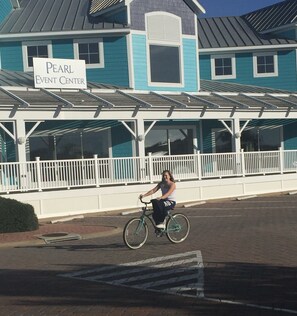 A building with a sign reading "Pearl Event Center" and a person riding a bicycle in front. - Cape Escape-Short Walk to Beach, Pet Friendly, Fenced Yard & Optional GC Rental (Cape Charles)