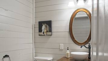 Ein Badezimmer mit einem Holzkosmetikschrank, einer weißen Toilette und Holzboden.