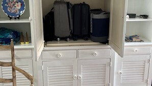 A white wooden wardrobe with multiple compartments, including hanging space for clothes and drawers for storage. - Prime location and the perfect getaway for two (Wrightsville Beach)
