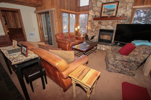 A cozy living room with leather sofas, a stone fireplace, and a flat-screen TV. - Mountainback #52, Loft, Corner (Mammoth Lakes)