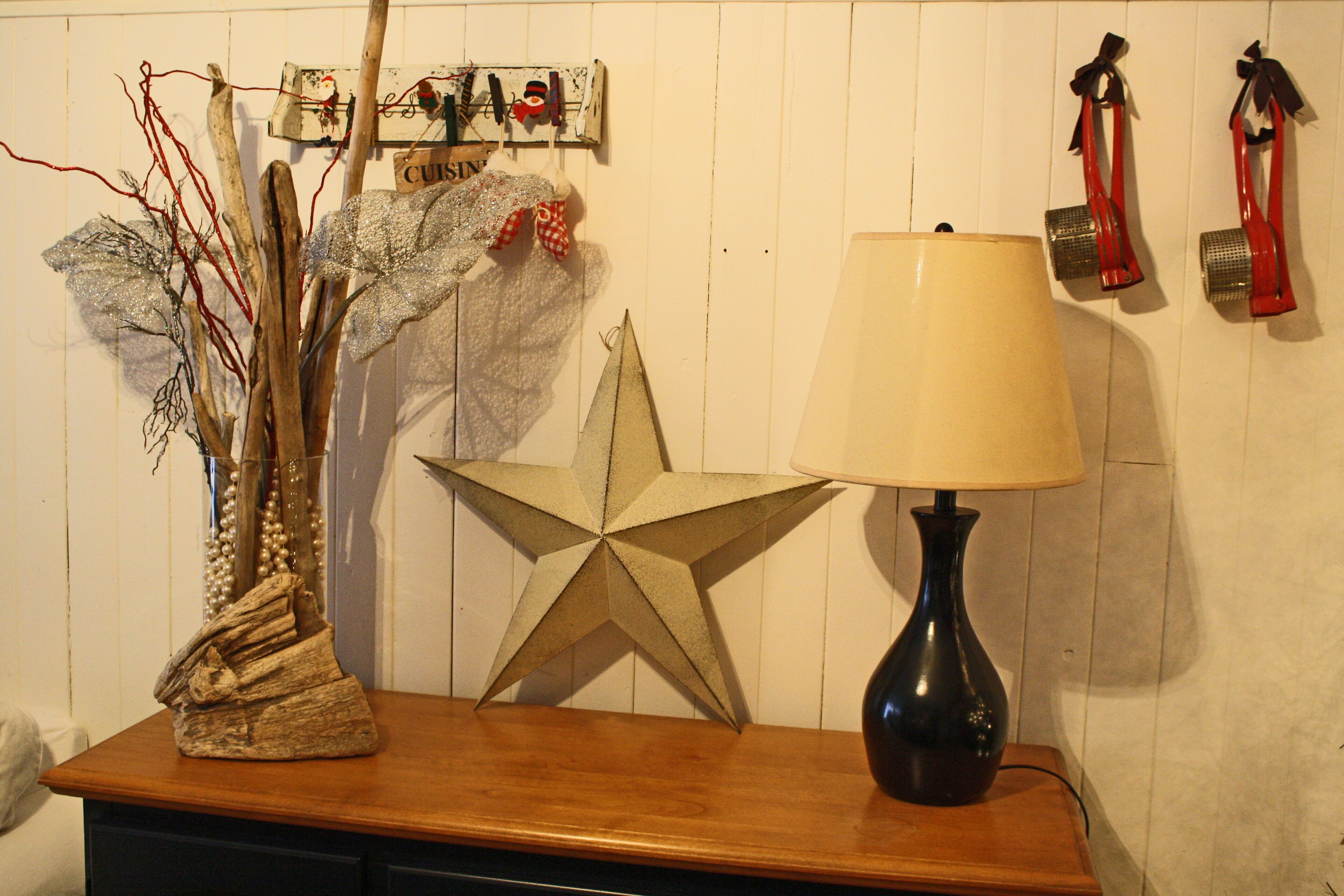 A wooden table with a star decoration, a lamp, and various hanging items.