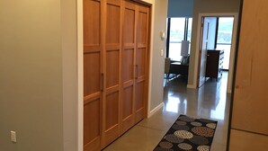 Ein Flur mit einem Holzschrank, einem gemusterten Teppich und Blick auf einen Essbereich mit Tisch und Stühlen.