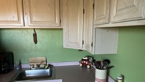 A kitchen with wooden cabinets, a sink, a stove, and a toy train on the counter. - Casita with Mountain View (Congress)