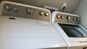 Twee witte Maytag wasmachines met voorlader en bedieningspanelen, inclusief temperatuur- en tijdsinstellingen.