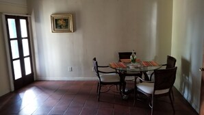 Un coin repas comprenant une table ronde, quatre chaises et un seul tableau encadré accroché au mur.
