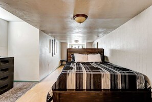 Ein Schlafzimmer mit einem Bett, einem Schminktisch und einer Deckenleuchte.