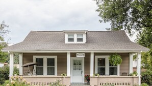 A two-story cottage with a front porch, a sign reading "DORLAND COTTAGE," and a small garden area with various plants and flowers. - Charming Cottage in town~on Appalachian Trail~Mountain Views~   (Hot Springs)