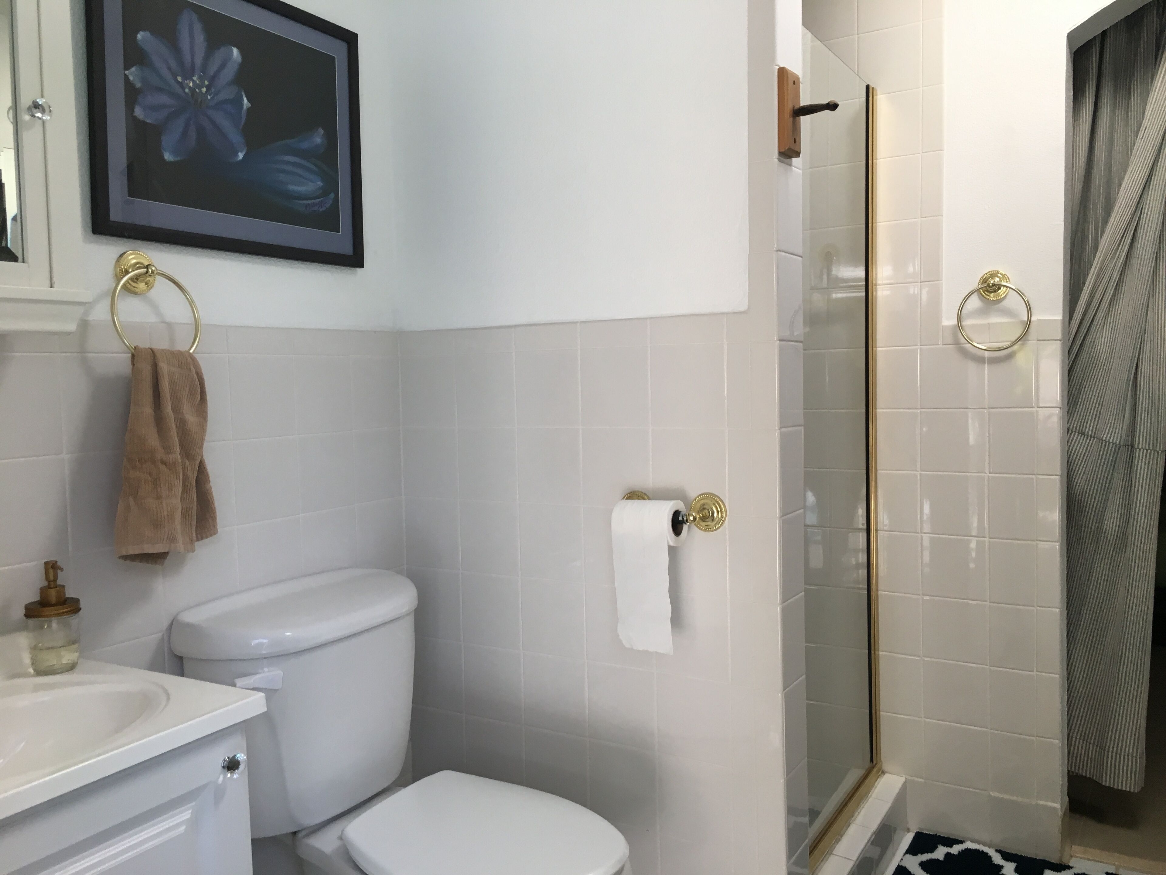 Un baño con inodoro, lavamanos y cabina de ducha de vidrio.