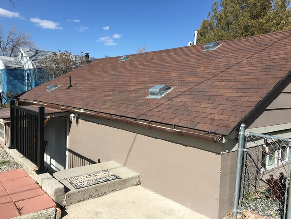 A residential building with a sloped roof, a covered porch, and a small window.
